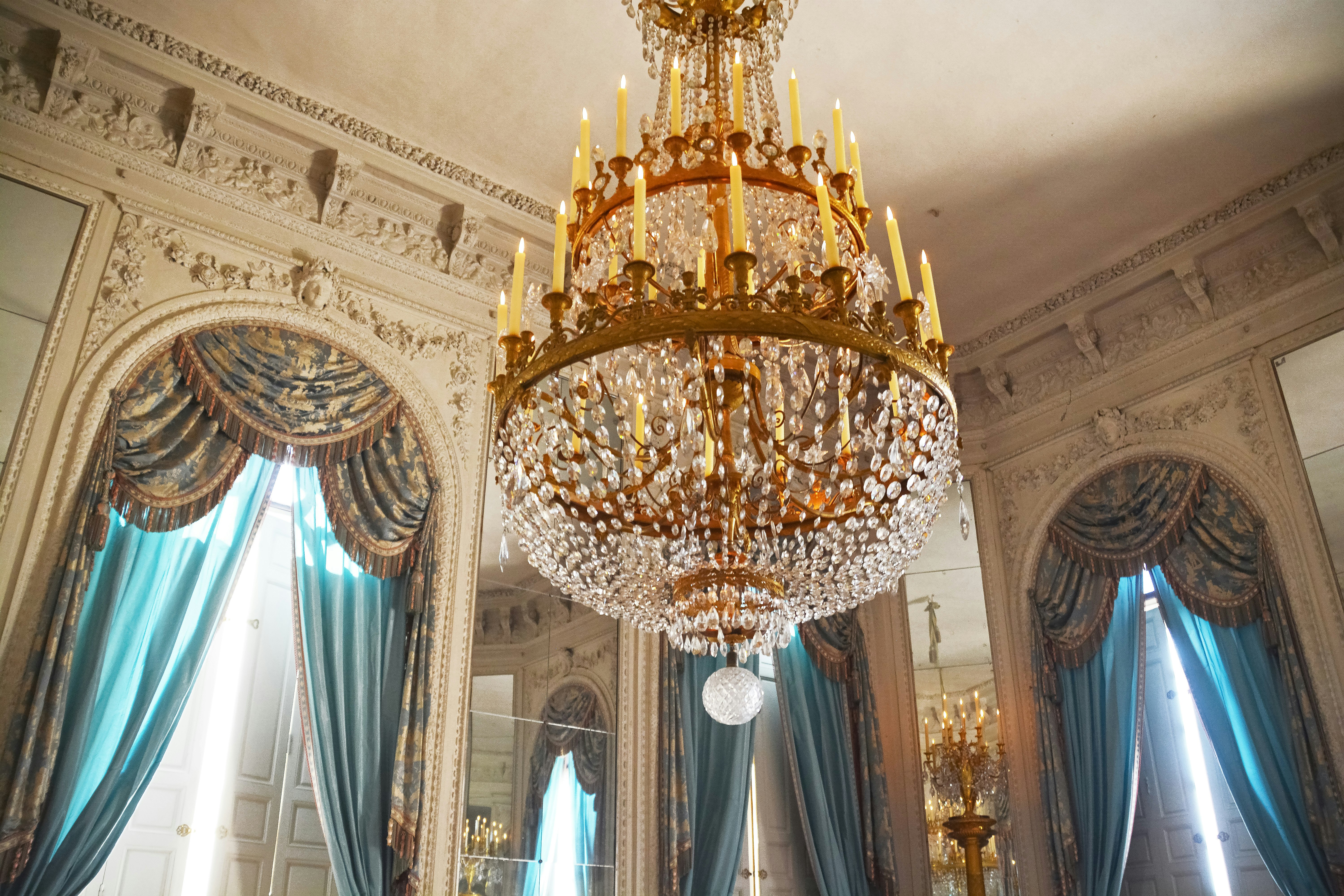 gold and white chandelier turned on inside room